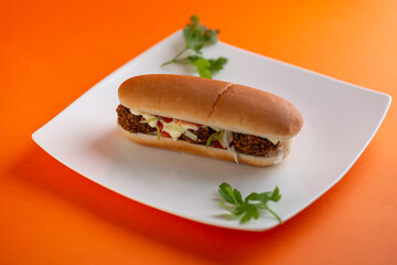 Turkish hot dog with falafel patties,thick layer of hummus, salad leaves,cucumbers,tomatoes and onions