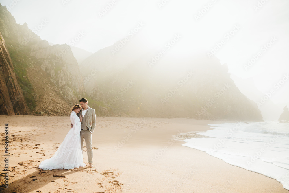 Wall mural bride in white wedding dress on the beach young couple on the beach. bridesmaids on the beach near t