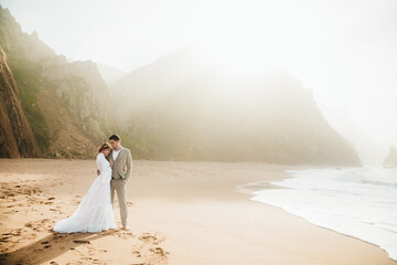 Fototapeta na wymiar bride in white wedding dress on the beach young couple on the beach. Bridesmaids on the beach near the ocean.