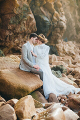Beautiful wedding couple standing between rocks in love