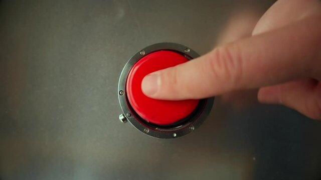 Finger presses the big red button 