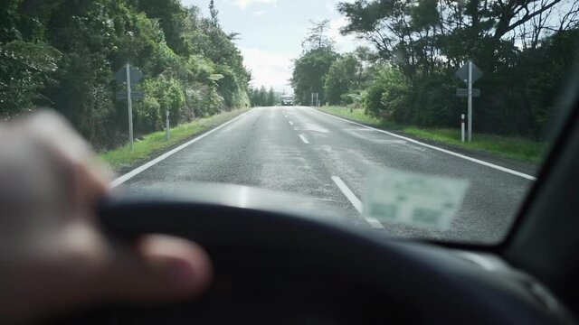 POV shot from steering wheel of car on country road in New Zealand
