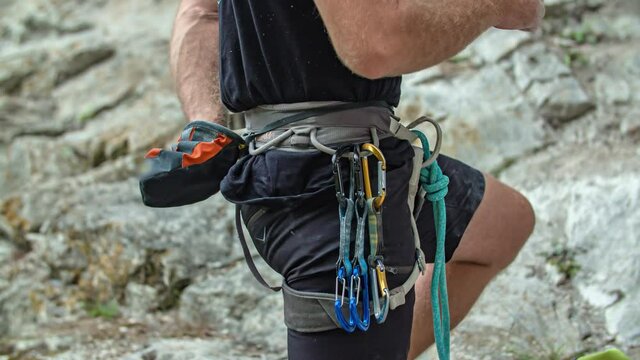 Climber use chalk bag while climbing mountain Burjakove Peci, Slovenia