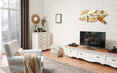 Decorative white classic furniture, television unit, drawer and home concept. Brick wall background.