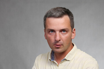 Fototapeta premium Portrait of an aggressive man on a gray background.