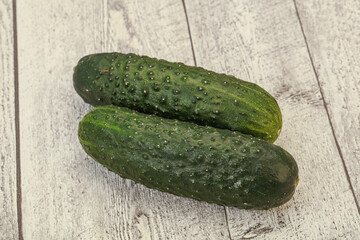 Green fresh cucumbers over background