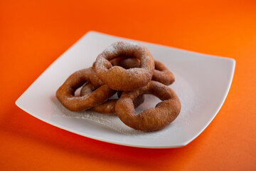 Traditional Transylvanian hungarian pastry, deep fried dough langos  with sugar close up on white plate