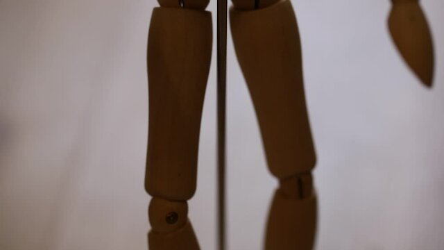 wooden figurine mannequin on a metal base in a dark room, bottom-up view, macro