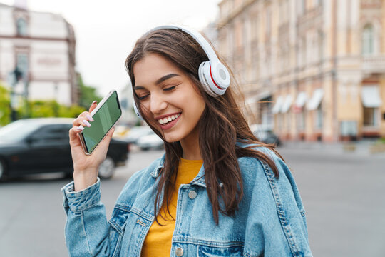 Image of woman listening music with smartphone and wireless headphones