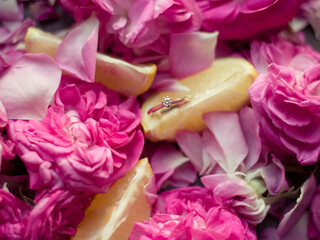 Petals of pink roses, lemons and a ring