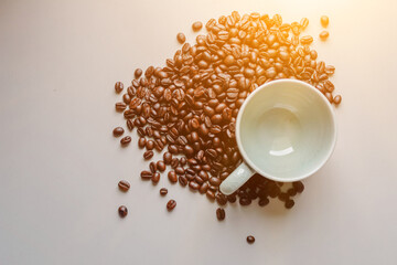 The coffee cups and roasted coffee beans were placed on a white table by the window in the dining room, as the coffee beans were prepared for filming a drink menu. Top View and Copy Space