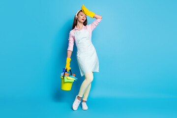 Full length photo of pretty lady house wife hold equipment disinfection bucket clean apartment tired wear headband latex gloves apron shirt pants shoes isolated blue color background