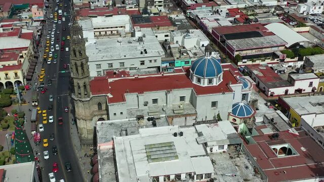 Aerial shot of a busy street. Multiple cars traveling on highway near central square plaza. Tepic Cathedral. Nayarit, Mexico. 