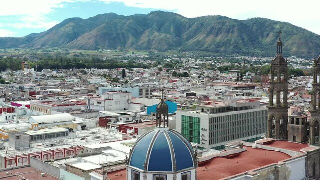 Aerial shot revealing Neo-Gothic Cathedral. Tepic Cathedral. Amazing view of a giant volcano in the background.  Nayarit, Mexico. 