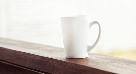 Fototapeta na wymiar The cup of coffee on the wooden handrail 