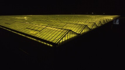Beautiful aerial view of the large greenhouse with light in it.