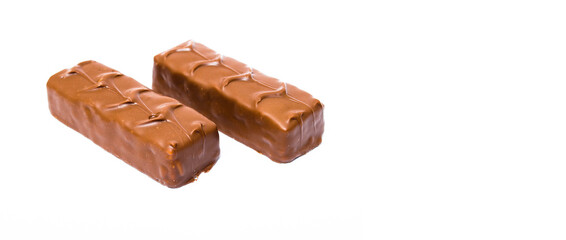 Two small snickers bars weighing 50 grams without packaging in macro are lying next to each other. Snickers two sticks, chocolates