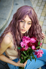 Girl with long curly burgundy hair and red flowers.