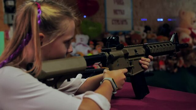 Girl teenager with a gun shoots at a shooting range.