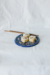 Sushi rolls on a plate with chopsticks on a white background. Stylish composition with sushi.