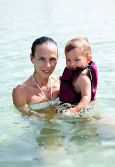 Mother and baby swim in the pool.