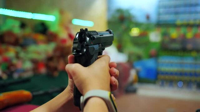 A teenage girl shoots at a shooting range with a pistol.