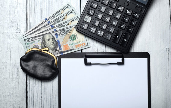 Silver calculator with gray keyboard is lying on desk cash dollar plots in home office setting. Calculation of family expenses social income population freelance irs situation growth research concept