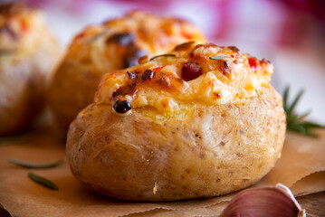 Baked potatoes stuffed with cheese, vegetables and rosemary