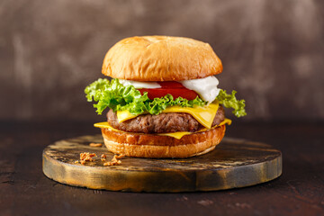 Close-up of home made tasty burger on wooden table.