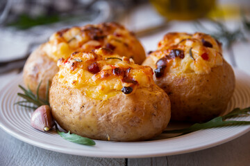 Baked potatoes stuffed with cheese, vegetables and rosemary