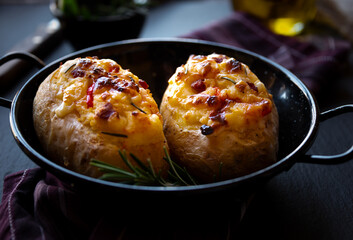Baked potatoes stuffed with cheese, vegetables and rosemary