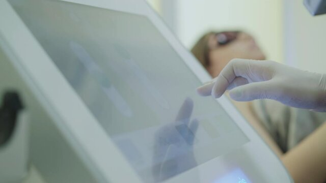 Hand of a beautician typing on the screen of the device in the beauty salon