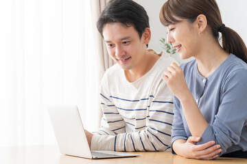 パソコンを見る夫婦