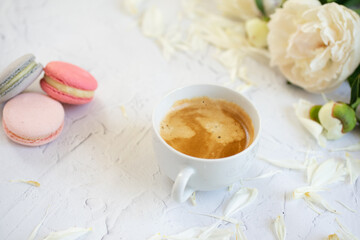 cup of coffee, white peonys and macarons 