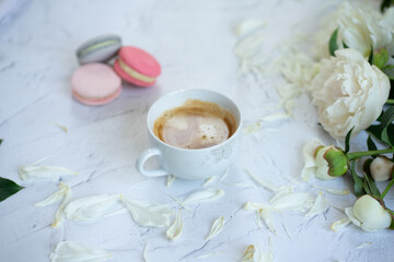 cup of coffee, white peonys and macarons 