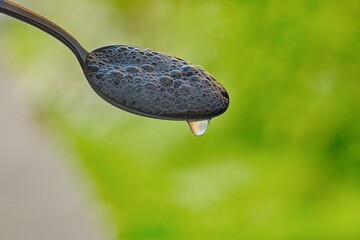 close-up of a spoon with foam and dripping water