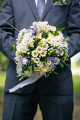 wedding bouquet in the hands of the groom