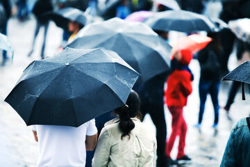 People with umbrellas on a rainy day outside