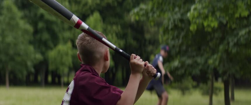 MED Two brothers or friends playing baseball in the park on a rainy day. Family time spent together. Shot with 2x Anamorphic lens