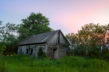 Old wooden vintage house in a clearing with green grass. abandoned villages of Ukraine.