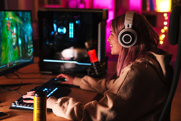 Image of caucasian happy girl in headphones playing video game