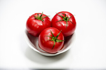 Tomatoes with drops of water isolated on white 
