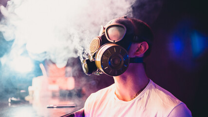 man in a gas mask Smoking a hookah and blowing smoke