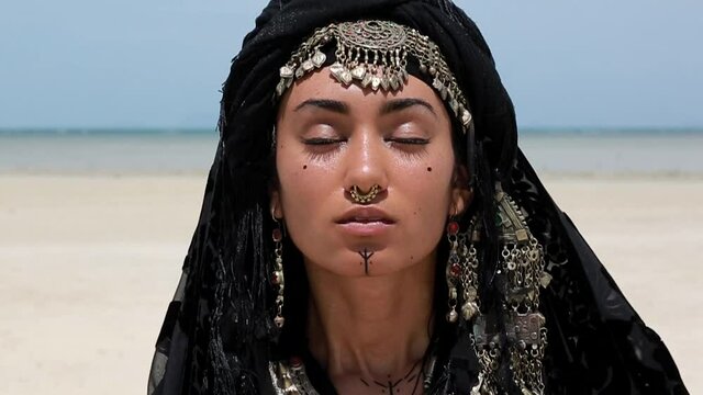 Beautiful young stylish tribal dancer. Woman in oriental costume close up portrait outdoors.