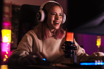 Image of excited girl smiling and playing video game on computer