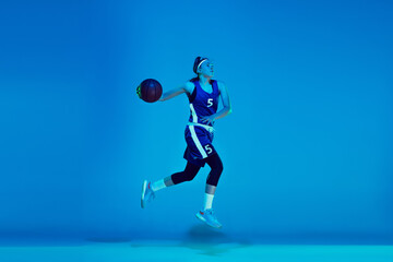 In high jump. Young caucasian female basketball player training, prcticing with ball isolated on...