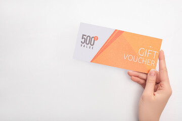Cropped view of woman holding gift voucher with 500 value lettering on white background