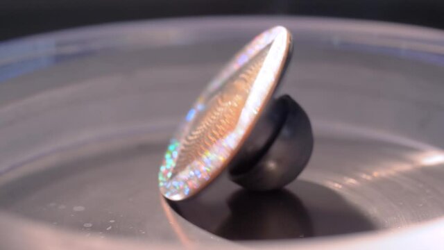 Super slow motion: metal gyroscope spinning top - interactive exposition at science exhibition museum - close up. Physics, experiment, education, laboratory equipment concept