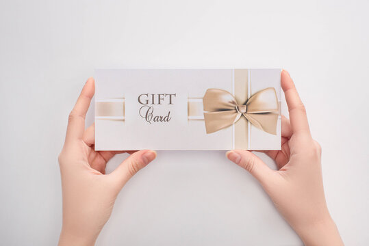 Top View Of Woman Holding Gift Card In Hands On White Background