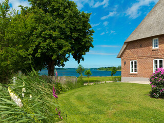 haus mit reetdach und garten mit Blick auf die Schlei in Schwansen, Schleswig-Holstein, Norddeutschalnd